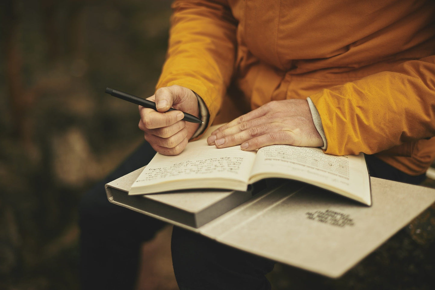 Person writing in journal on their lap